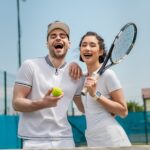 excited-man-and-happy-woman-holding-tennis-ball-an-2Q4WDB7.jpg